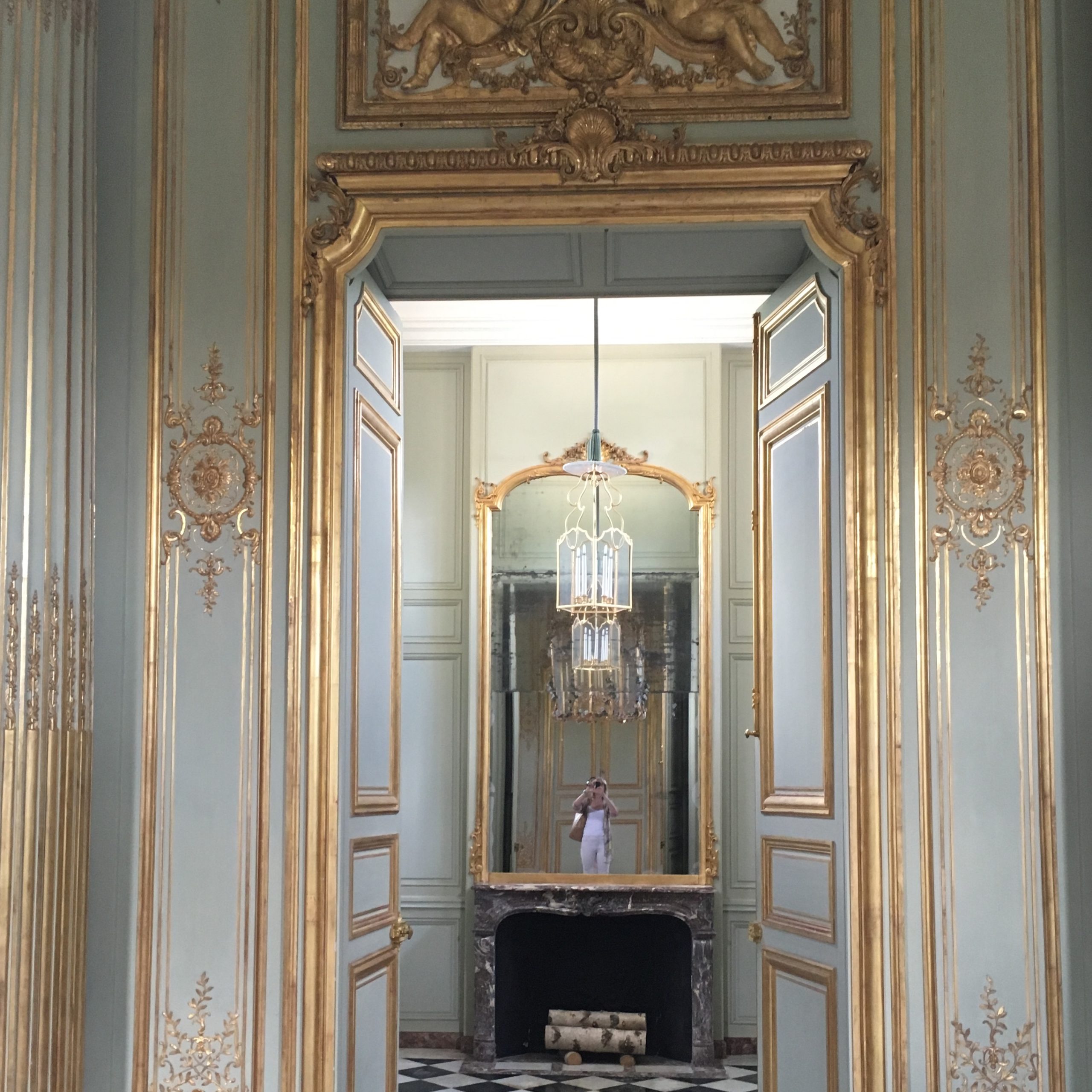 A beautiful mirror seen through a gilded doorway